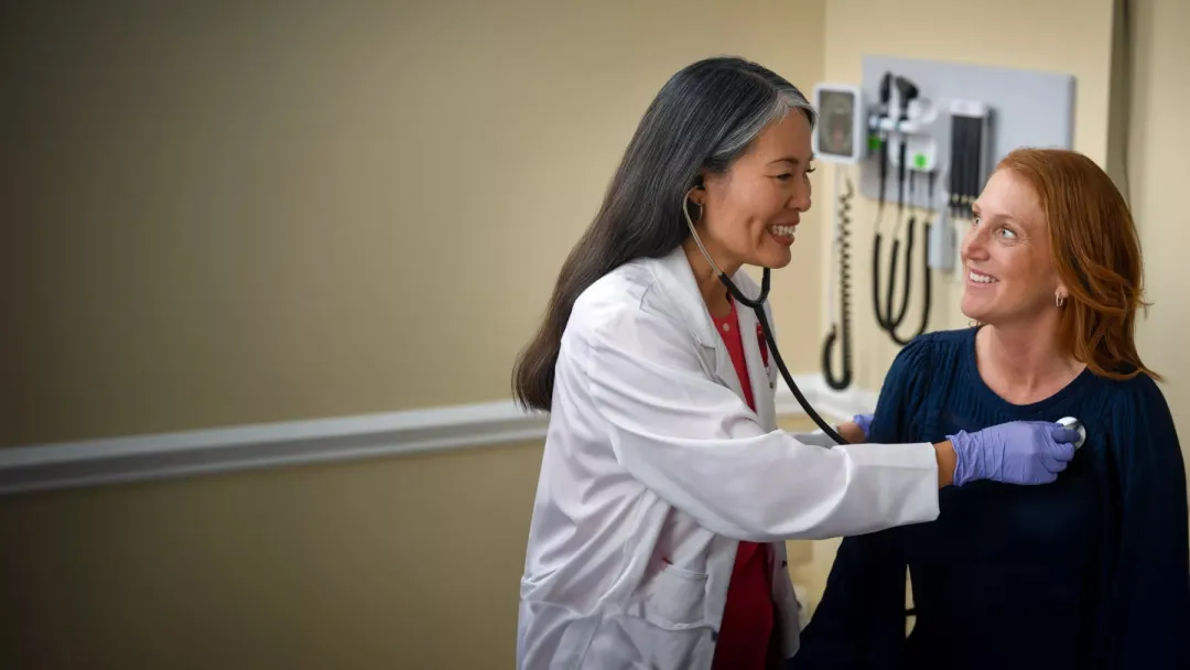 A Provider Checks Her Patient's Vitals in an Exam Room