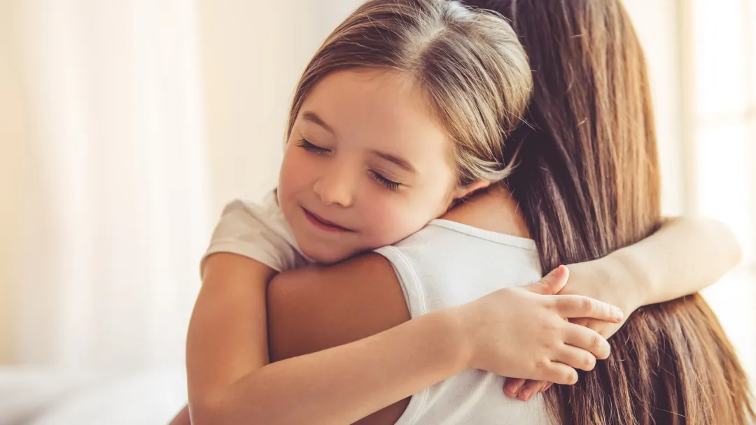 Young child embracing her mother
