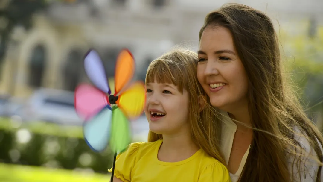 Mom and daughter playing with a pinwheel.