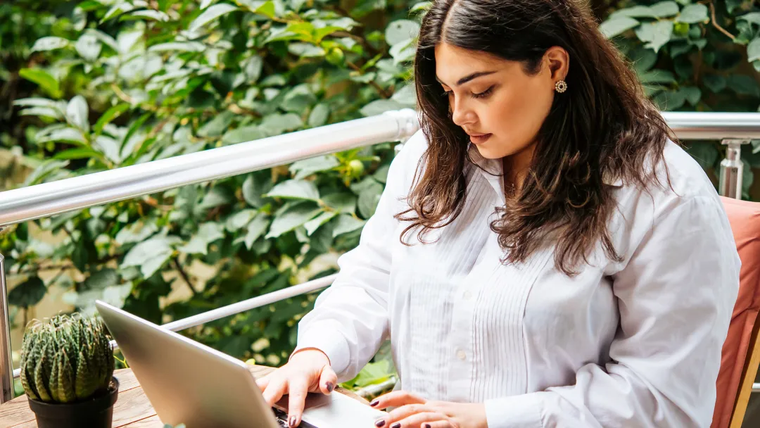 Woman on her laptop outside.