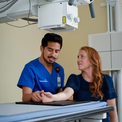 Nurse helping patient get x-ray completed.