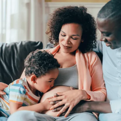A pregnant woman with her husband and son.