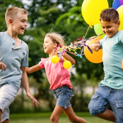 Kids running and playing with balloons