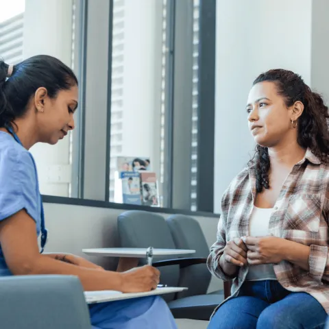 A Woman Speaks to a Provider as the Physician Takes Notes