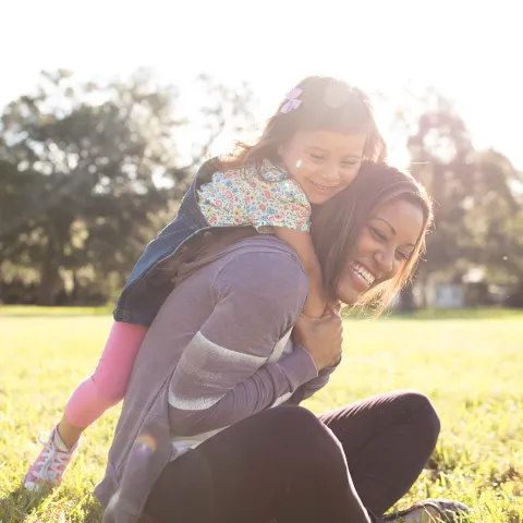 Daughter climbing on her favorite jungle-gym: her mother.