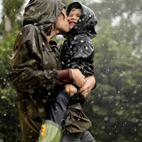 Mom and little boy playing in the rain.