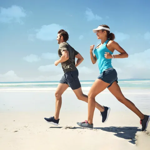 A couple running on the beach.