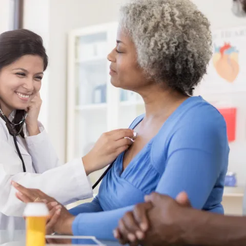 A doctor listens to a patient's lungs.