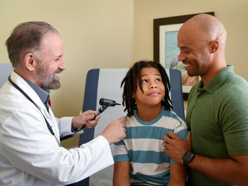 Provider checking boy's ear for infection