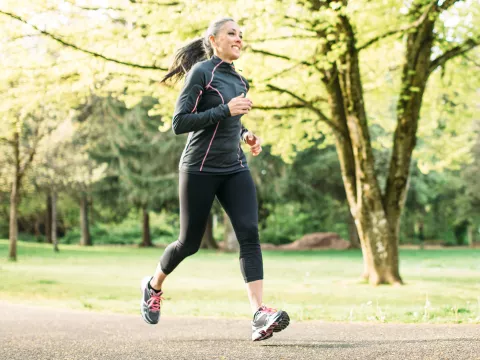 A Woman Runs Through a Wooded Park