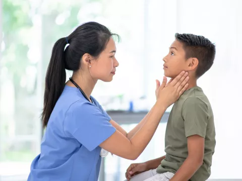 A Physcian Examines a Pediatric Patient's Neck
