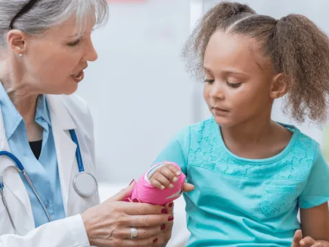 A Doctor Check's a Little Girl's New Cast