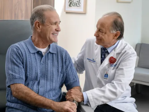 Physician smiling and speaking to older patient
