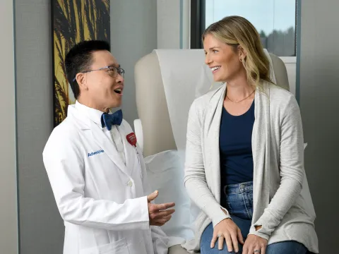 Doctor speaking to female patient on operating chair