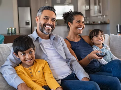 Family watching television at home together.