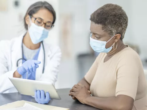 A woman at the doctor wearing a mask.