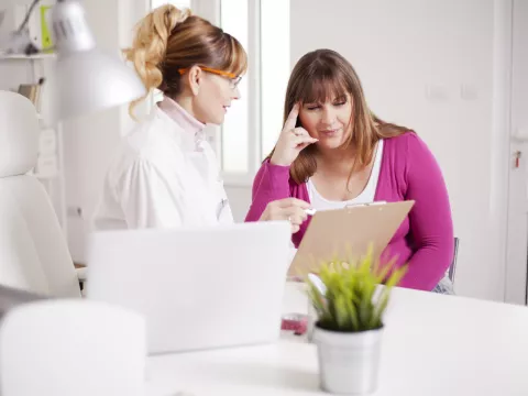 An adult woman meets with her doctor