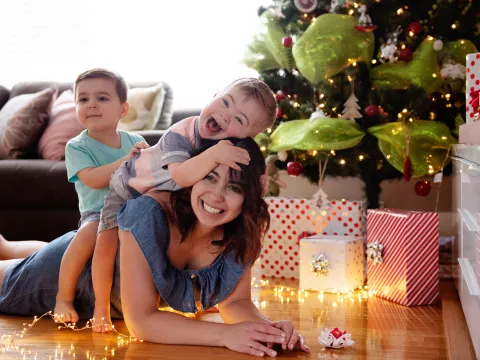 Caucasian mother with two sons laying under a Christmas tree