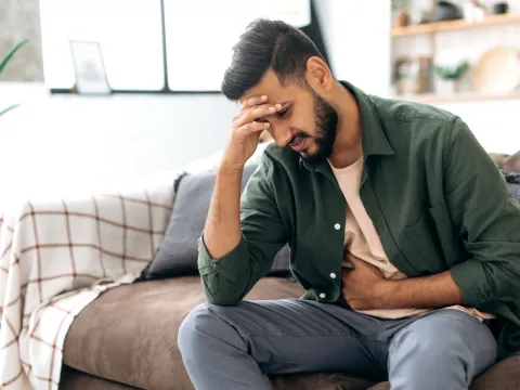 A sick man holding his forehead in his hand