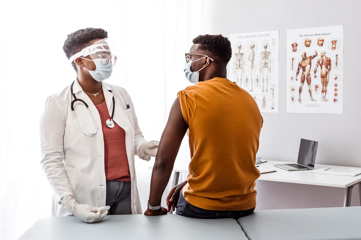 A Doctor Examines Her Patient in an Exam Room while Wearing PPE